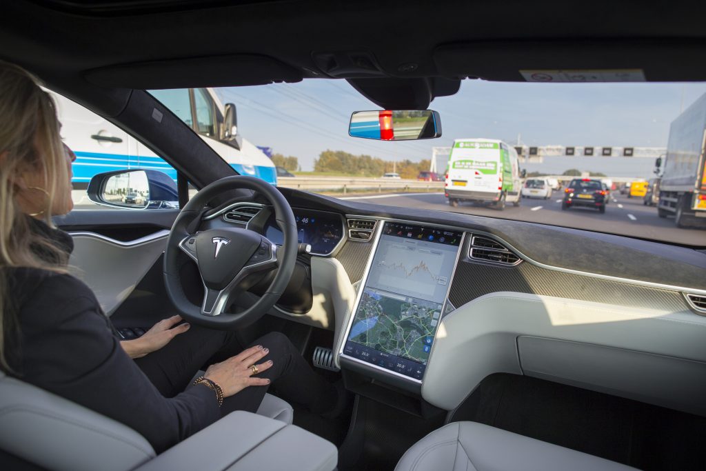 An employee drives a Tesla Motors Inc. Model S electric automobile, equipped with Autopilot hardware and software, hands-free on a highway in Amsterdam, Netherlands, on Monday, Oct. 26, 2015. Tesla started equipping the Model S with hardware -- radar, a forward-looking camera, 12 long-range sensors, GPS -- to enable the autopilot features about a year ago. Photographer: Jasper Juinen/Bloomberg via Getty Images